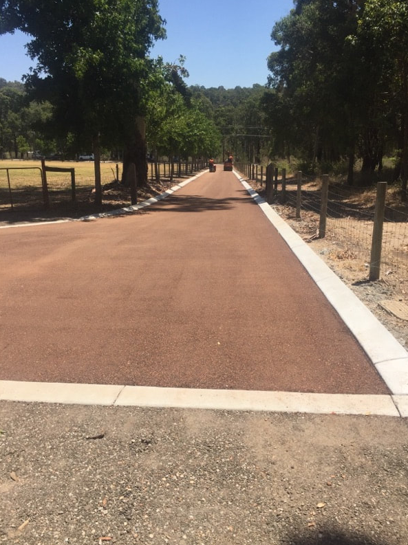This is a photo of a hot spray & seal bitumen roadway which is in the process of being installed by Harrisville Asphalt & Bitumen Surfacing